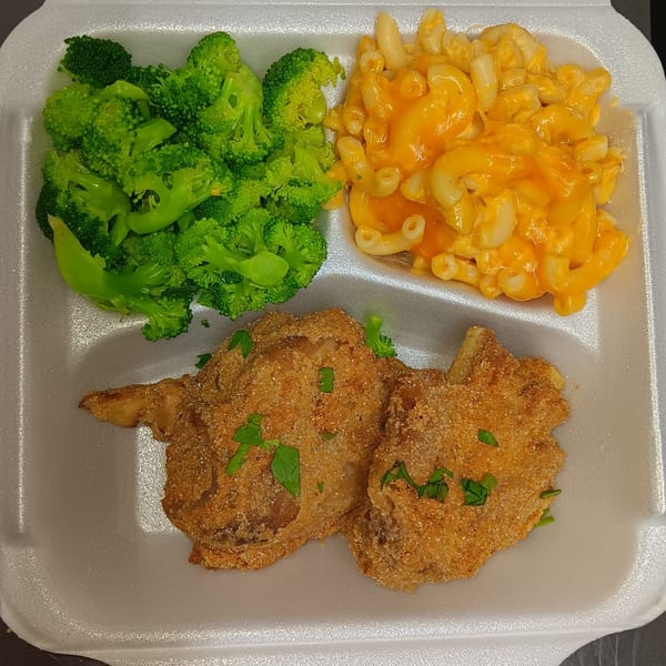 Southern fried fish with macaroni and cheese and steamed broccoli in a white takeout container.
