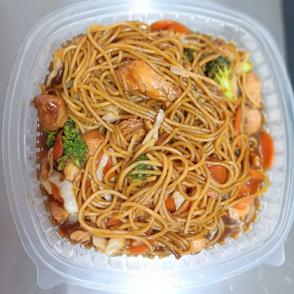 Southern-style lo mein with chicken, broccoli, carrots, and cabbage in a clear plastic container.